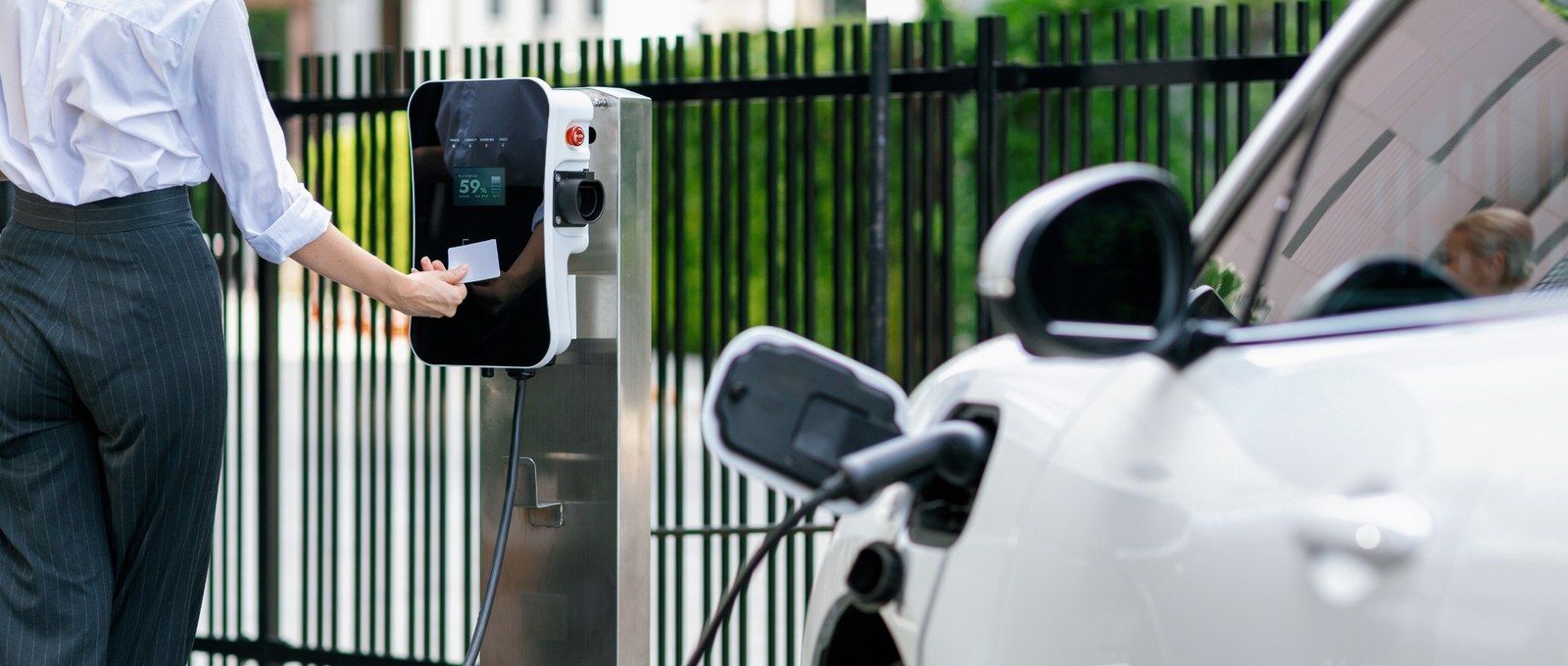 Activation d’une borne de recharge par badge près d’une voiture électrique